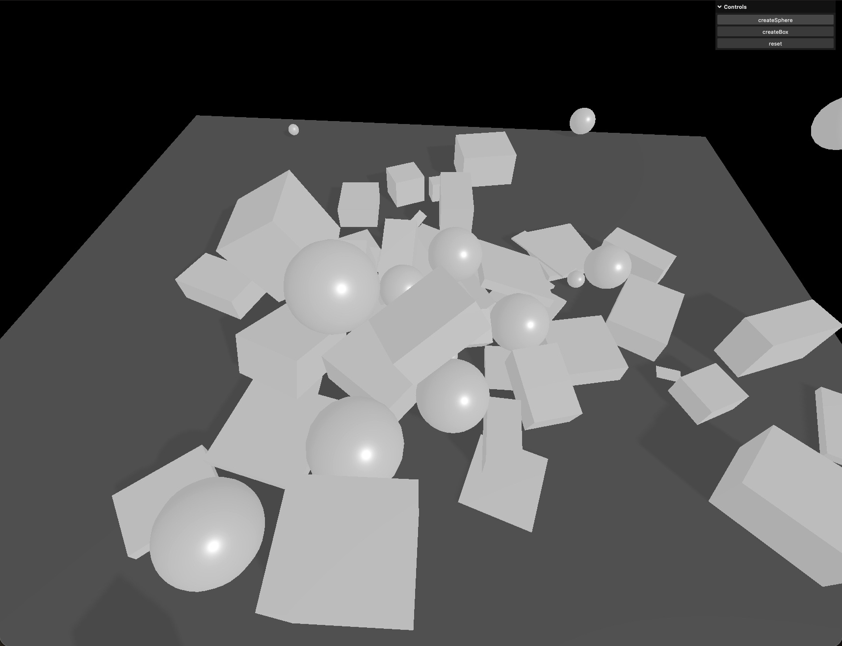 Physics sandbox — white spheres and boxes piled on a grey floor with a controls panel